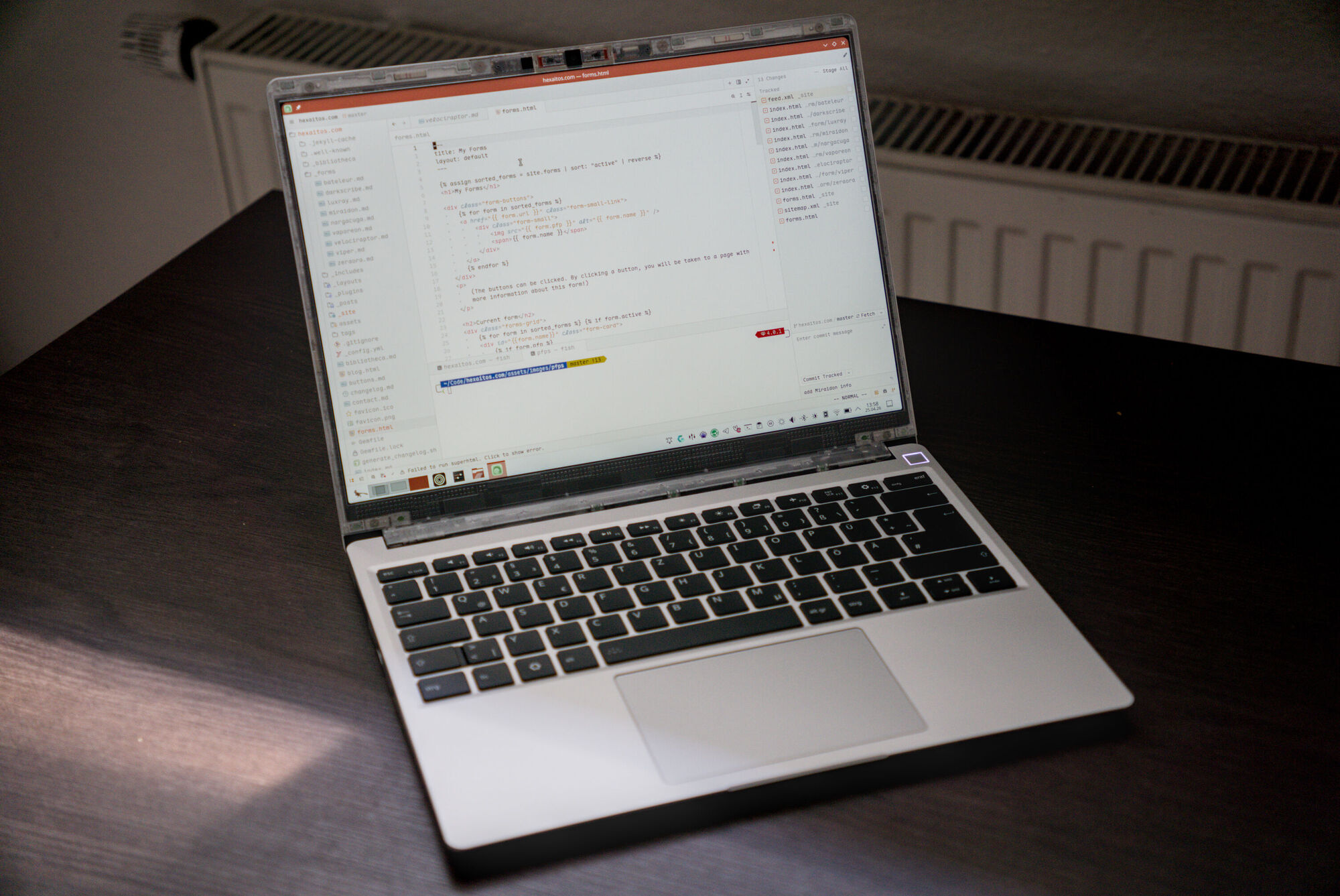 A photo of an opened Framework 13 laptop standing on a desk.